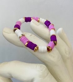 A purple clay bead bracelet as an ombre, with gold rings. Very stretchy, can be used as a bracelet, a fidget, and very stretchy and will fit any arm. Includes the colors white, light purple, purple, and dark purple showing a collection of ombre. Purple Clay Bead Bracelet, Preppy Bracelets, Golden Rings, Clay Bead Bracelet, Yellow And Purple, Clay Bead, Golden Ring, Clay Beads, Bead Bracelet