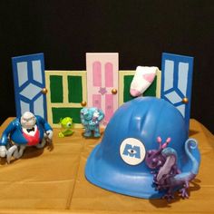 a blue hard hat sitting on top of a wooden table next to toy figurines