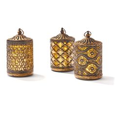 three golden canisters sitting next to each other on top of a white surface