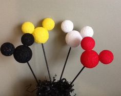 there are three mickey mouses in the vase on the table with some black and white balls