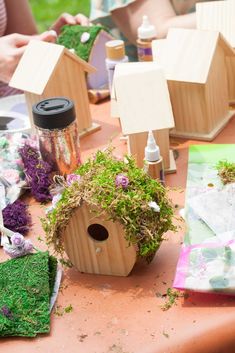 a table topped with wooden bird houses and plants