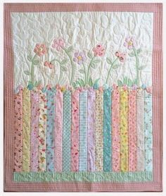 a quilted wall hanging with flowers and stripes in pastel pink, blue, green, yellow