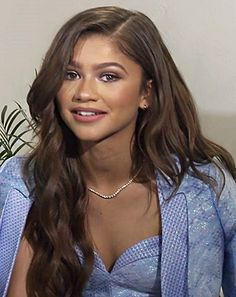 a woman with long hair wearing a blue dress