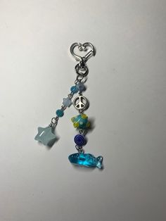 a keychain with charms and beads hanging from it's side on a white surface