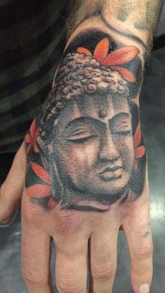 a man's hand with a tattoo on it and a buddha head in the middle