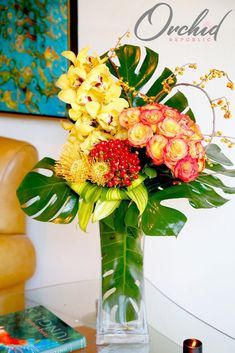 a vase filled with lots of flowers on top of a table next to a book