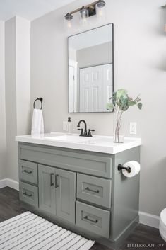 a bathroom with a sink, mirror and rug