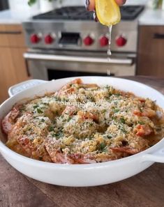 someone is sprinkling parmesan cheese on top of a casserole dish