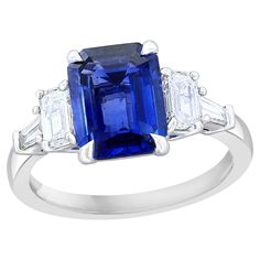 a blue sapphire and diamond ring with three baguets on the side, in white gold