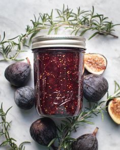 figs and rosemary sprigs surrounding a jar of jam