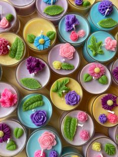 many different colored candles with flowers and leaves on them are arranged in the shape of circles