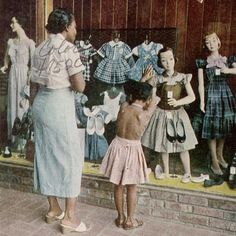 an old photo of children in front of a store window with mannequins