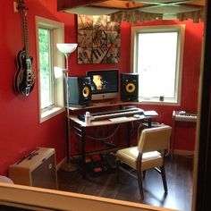 a room with red walls and two computer monitors