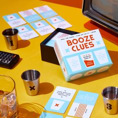 a box of booze clues sitting on top of a table next to cups and coasters