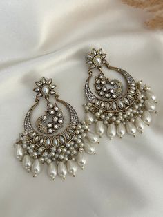 High quality kundan  work classic chandbali with pearl and faux american diamond detailing statement earrings, available in colors.  Lightweight  Dimensions- Earrings length- 3 inches  Style tip- Pair it with any beautiful traditional outfits  and flaunt with Unique style of collection from us. Perfect match for Festival and Traditional wear.  Take Care Tips-  Kee away from perfume, Hair spray and. Moisture.  Store in dry place , Ziplock bag or Airtight box.    Clean with dry cloth.  Jewellery i Party Kundan Chandbalis With Pearl Drop, Festival Chandbali Earrings With Mirror Work, Chandbali Earrings With Mirror Work For Festivals, Temple Jewelry Chandbali Danglers With Mirror Work, Party Chandbali Chandelier Earrings With Gota Work, Festival Mirror Work Chandbali Earrings, Chandbali Danglers With Mirror Work For Festive Occasions, Diwali Chandbali Earrings With Mirror Work, Bollywood Chandbali Bridal Earrings With Mirror Work