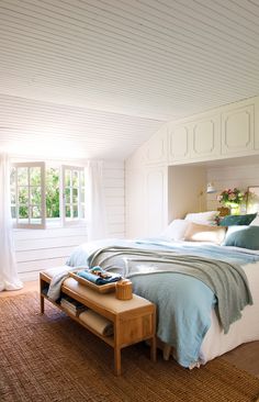 a bed room with a neatly made bed next to a window and a rug on the floor