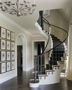 a spiral staircase in a home with pictures on the wall