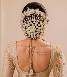 the back of a woman's head with flowers in her hair