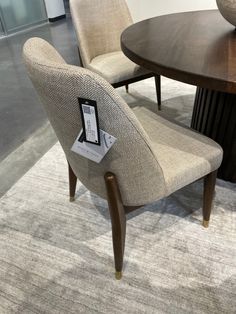 a table with two chairs and a book on top of it next to a round wooden table