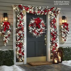 christmas wreaths and lights on the front door of a house