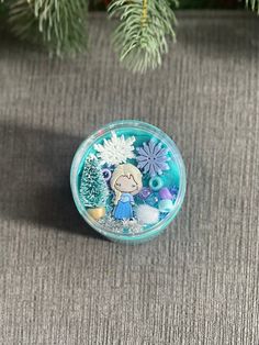 a small glass container sitting on top of a carpeted floor next to a christmas tree