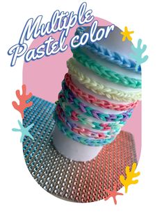 a stack of multicolored bracelets sitting on top of a white cup with the words multiple pastel color