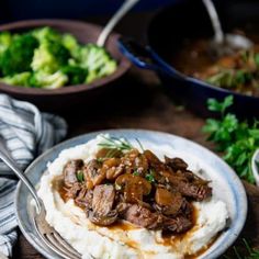 a plate with mashed potatoes topped with meat and gravy