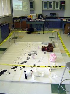 an empty classroom with stuffed animals on the floor and caution tape taped around the room