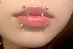 a woman with piercings on her nose and tongue