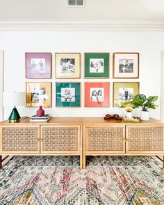 a living room with pictures on the wall and a rug in front of an entertainment center