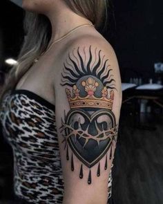 a woman with a heart and crown tattoo on her arm