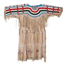 Beautiful tanned elk hide dress. The yoke with underlying rows of larger red, white, green and blue beads. Shoulder strips lazy stitched with 20/0 cut seed beads and containing arrows with other geometrics. Rose and painted florals near hem. Period: Last half of the 20th century. Origin: Plateau Size: 45" x 48". Family Owned & Operated Cisco’s Gallery deals in the rare, exceptional, and one-of-a-kind pieces that define the history of America and the Old West. Our pieces range from American India Buckskin Dress, Native Fashion, Native American Dress, Wild Fashion, Beaded Cape, African American Artwork, Painted Florals, Native American Clothing, American Dress