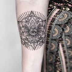 a woman's arm with a black and white tattoo design on the left forearm