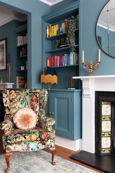 a living room filled with furniture and a fire place in front of a book shelf