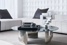 a glass table sitting in front of a white couch