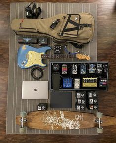 an assortment of musical instruments and accessories laid out on a rug next to a guitar case