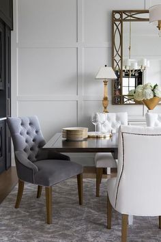 a dining room table with chairs and a mirror on the wall in front of it