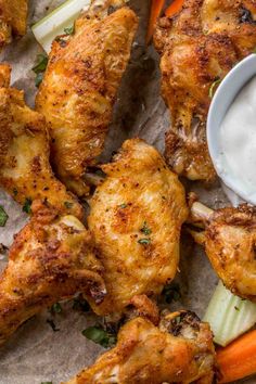 chicken wings with ranch dressing and carrots on parchment paper, ready to be eaten