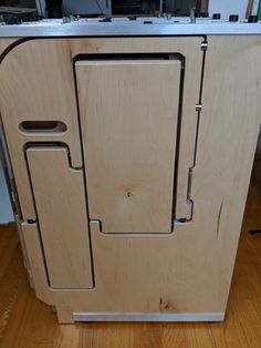 a wooden cabinet sitting on top of a hard wood floor next to a wall mounted oven