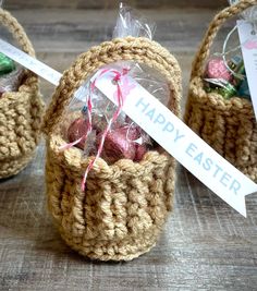 three crocheted baskets with easter eggs in them and a sign that says happy easter