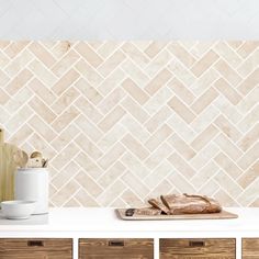 a kitchen counter topped with wooden drawers next to a wall mounted tile backsplash