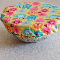 a yellow flowered pot cover sitting on top of a counter