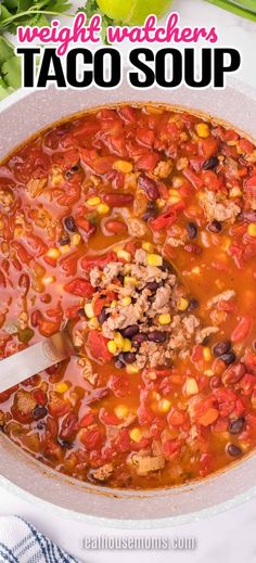 a large pot filled with taco soup on top of a white table next to vegetables