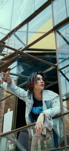 a woman standing on the side of a glass building