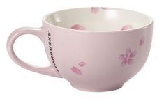 a pink coffee cup with flowers painted on it