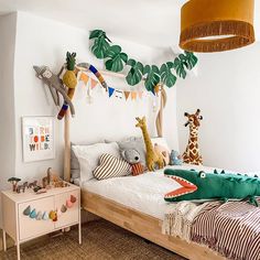 a child's bedroom with stuffed animals on the bed and toys hanging from the ceiling