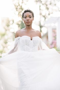 a woman in a white dress is posing for the camera