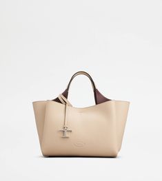 Bag in soft exposed grain leather, with Tod's logo stamped on the front, flat handles and removable shoulder strap. The interior comes with three compartments separated by zipped central pockets. An elegant creation enhanced by distinctive iconic detailing, such as the metal T Timeless pendant and T-stitching. Beige Calf Leather Bag With Top Carry Handle, Beige Calf Leather Bag, Designer Cream Business Bags, Timeless Beige Soft Leather Bag, Cream Calf Leather Bag For Everyday Use, Cream Rectangular Calf Leather Bag, Everyday Cream Calf Leather Bag, Tan Calf Leather Satchel Bag, Tan Bag With Double Handle And Removable Pouch