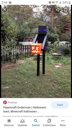 an orange and black electronic device sitting on top of a grass covered field next to a fence