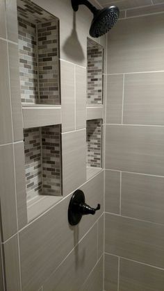 the shower head is mounted to the wall in this bathroom with white and gray tile